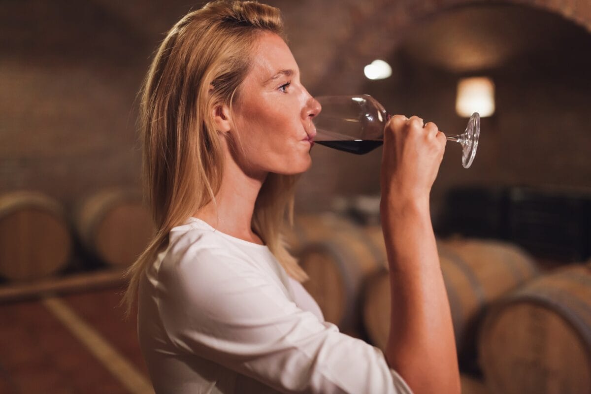 Beautiful woman oenologist tasting wine
