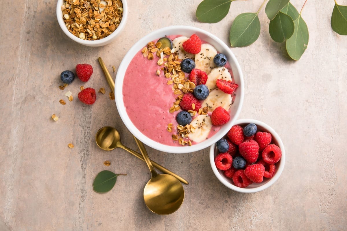 Bols de smoothie à l'açaï pour l'été. Bol à déjeuner avec fruits et céréales, gros plan, vue de dessus, espace pour le texte.