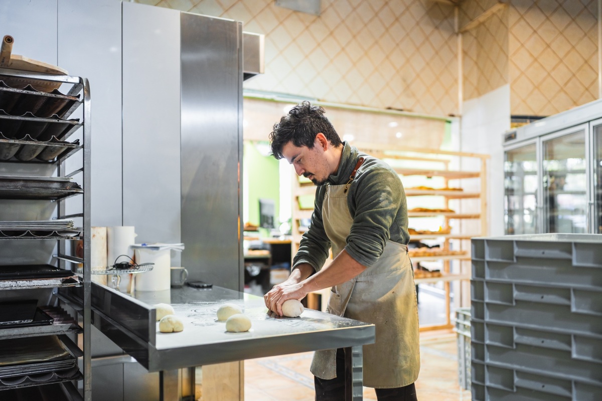 Boulanger pétrissant la pâte dans une boulangerie moderne