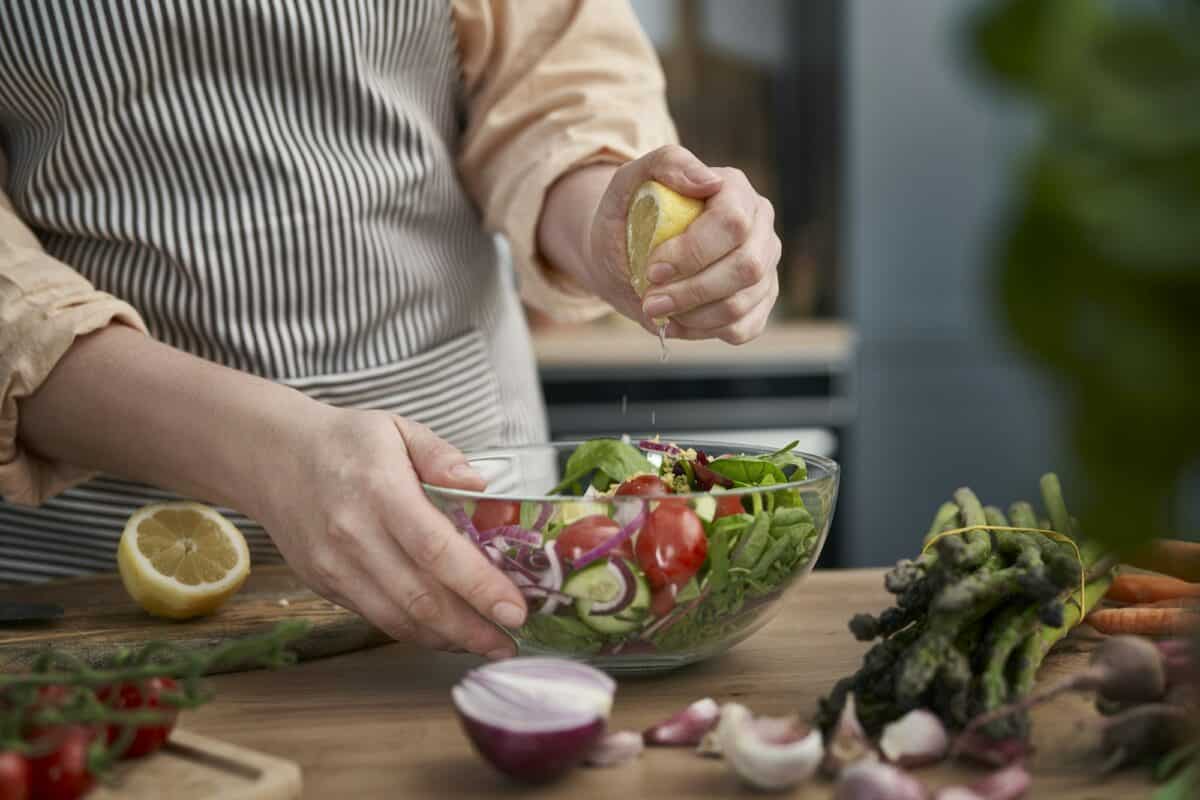 Close up of woman squeeze lemon for salad