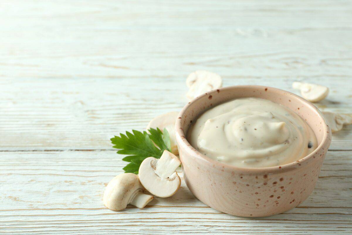 Concept de nourriture savoureuse avec sauce aux champignons sur fond blanc en bois