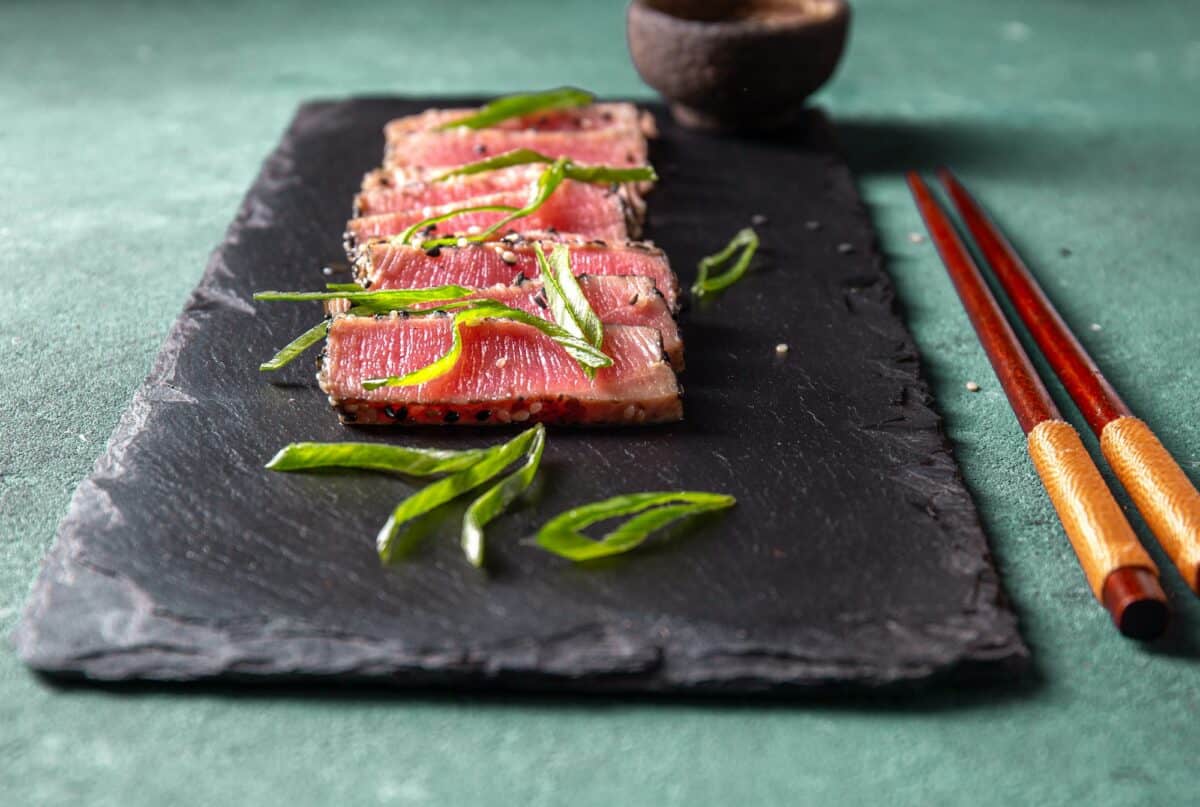 Cuisine japonaise. Thon tataki. Sashimi de thon cru searahi con cesamo sur planche noire.