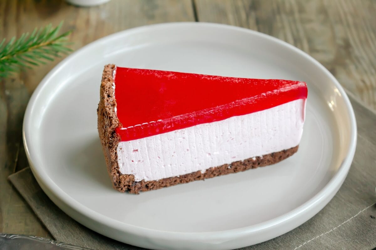 Délicieuse tranche de cheesecake à la cerise rouge et à la gelée de fraise. Noël, nouvel an, dessert, fêtes de fin d'année