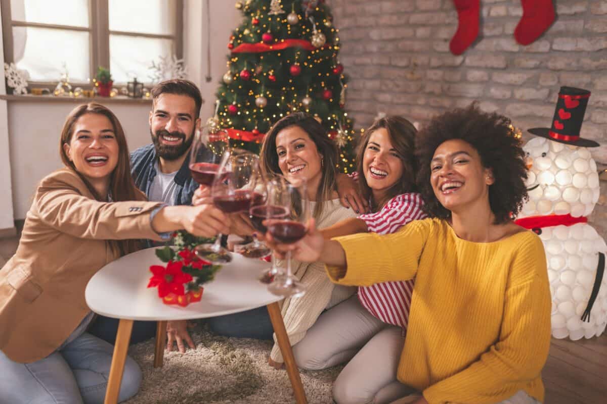Des amis portent un toast avec des verres de vin le jour de Noël