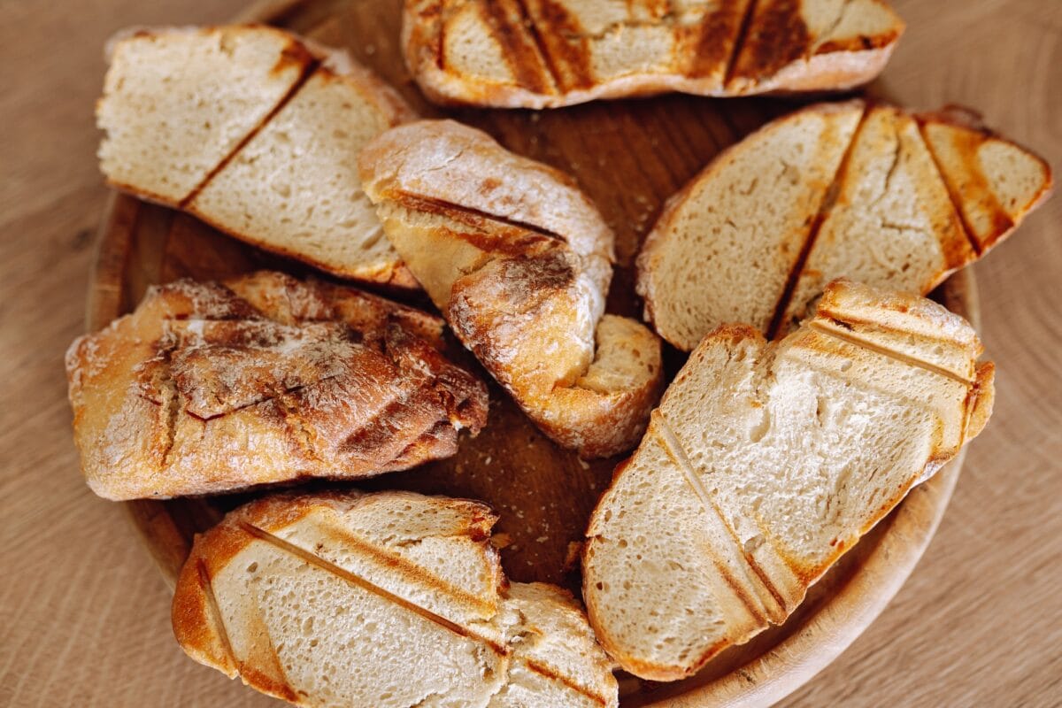 dried wheat bread, croutons, pieces, on a wooden round board