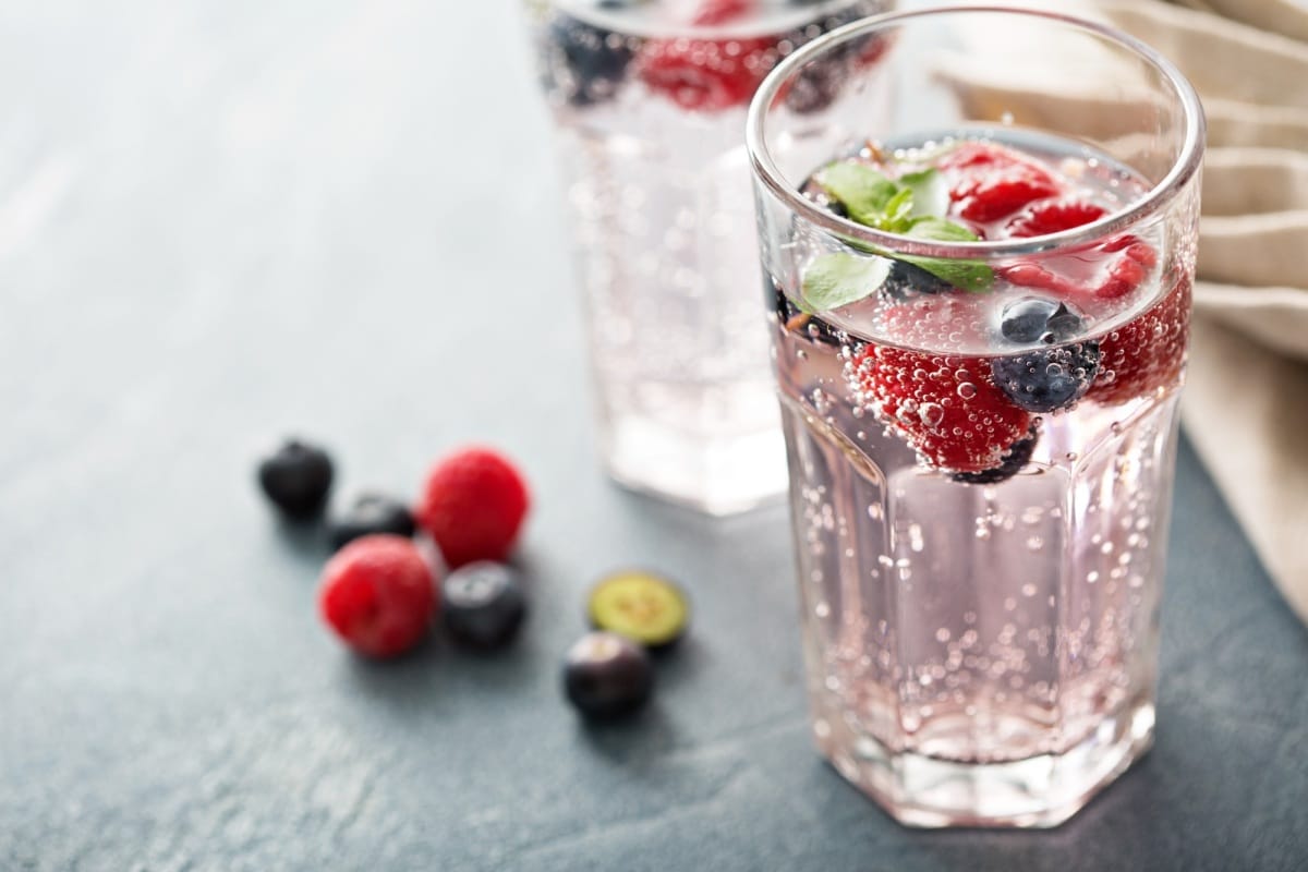 Eau pétillante avec des framboises et des myrtilles