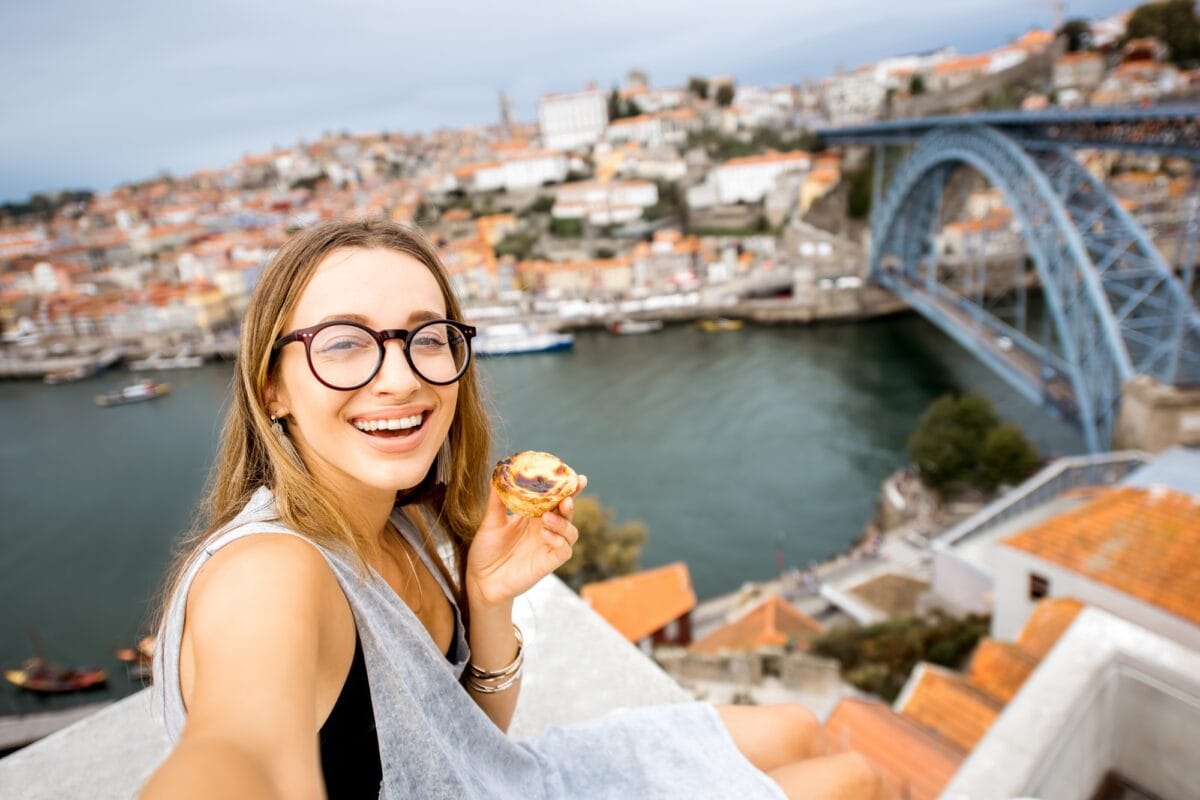 Femme avec un dessert portugais à Porto