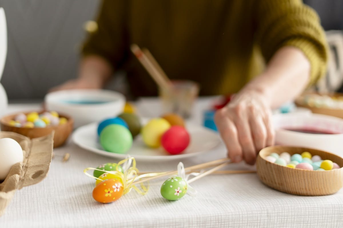 Woman preparing colorful easter eggs for easter celebration