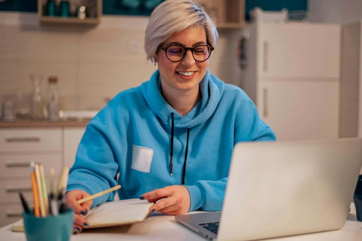 Femme travaillant sur un ordinateur portable dans la cuisine à la maison