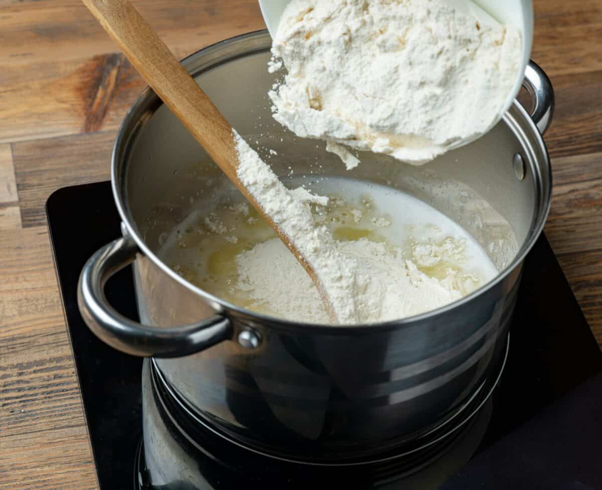 flour is poured into a pot with hot water and butter