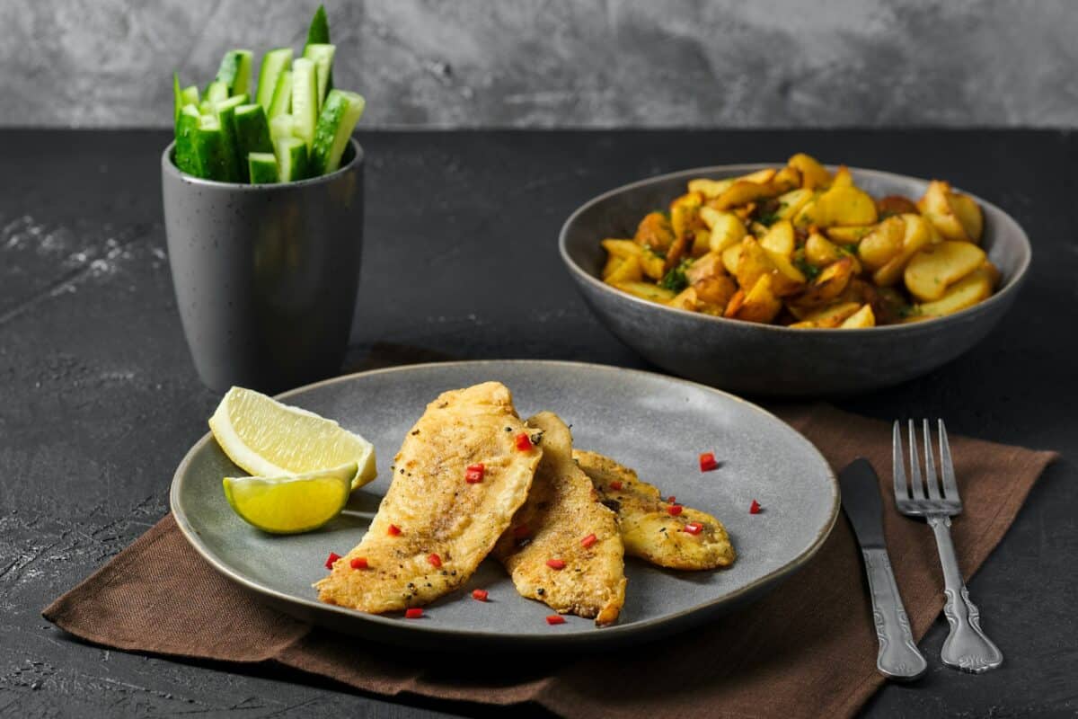 Fried breaded hake fillet with spice and roasted potato wedges