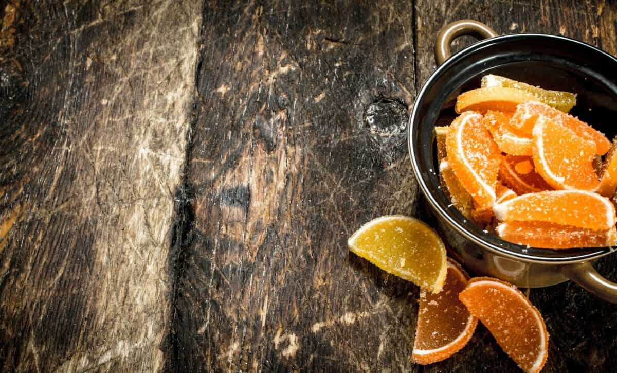 Fruit jelly in bowl. On wooden background.