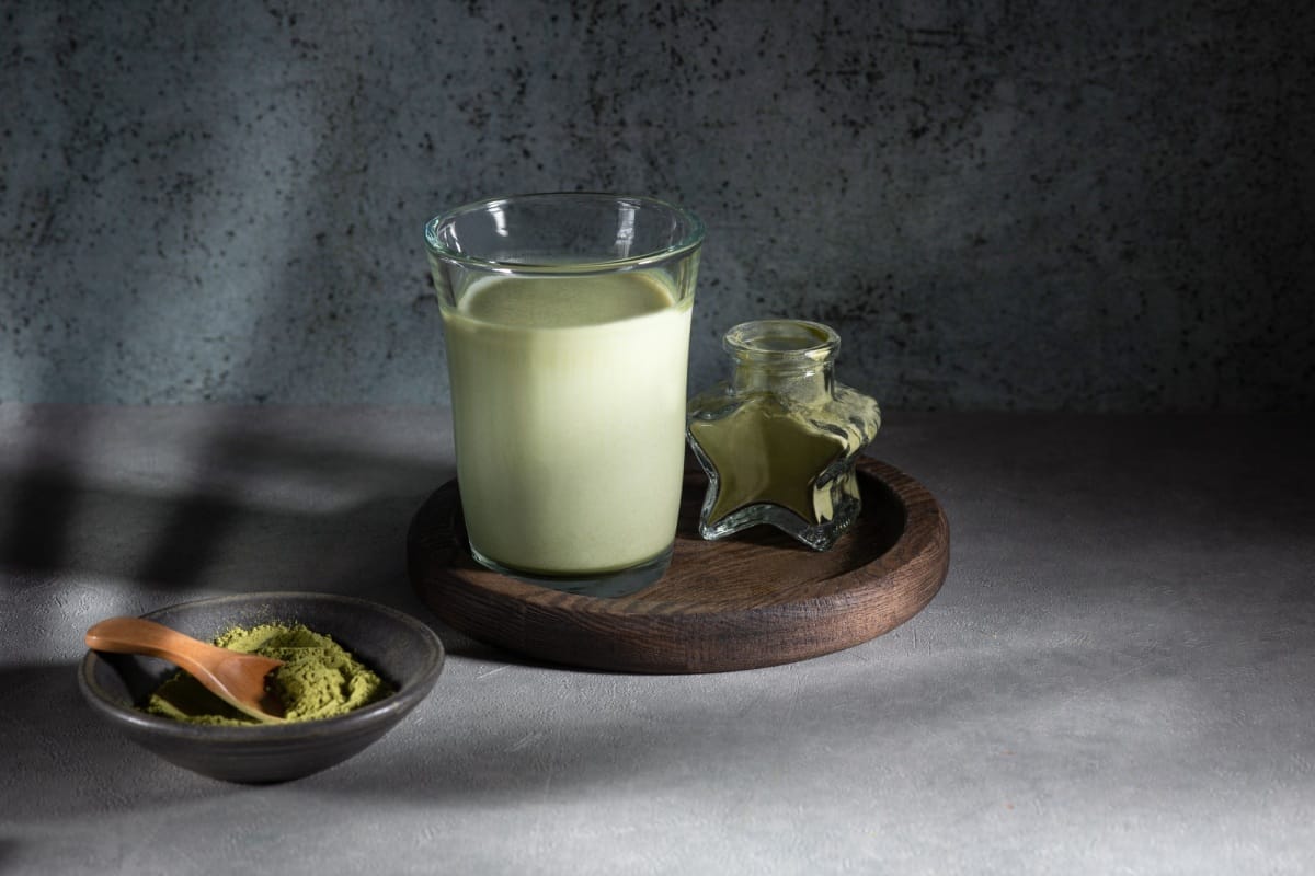 Glass of Dalgona Matcha latte tea with whipped tea. Close up. Space for text.