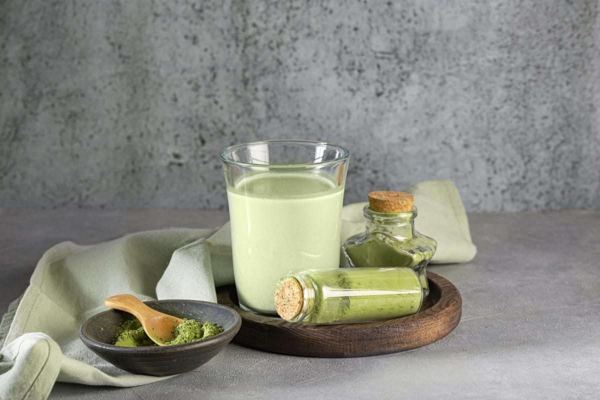 Glass of Dalgona Matcha latte tea with whipped tea. Close up. Space for text.
