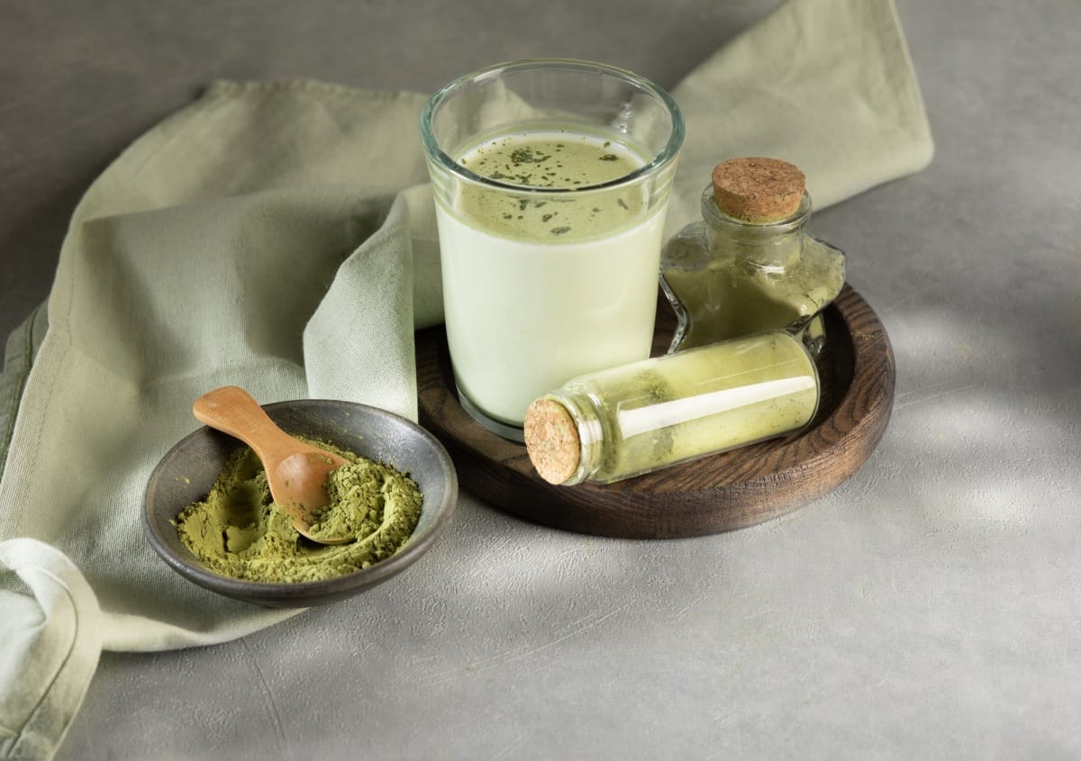 Glass of Dalgona Matcha latte tea with whipped tea. Close up. Space for text.