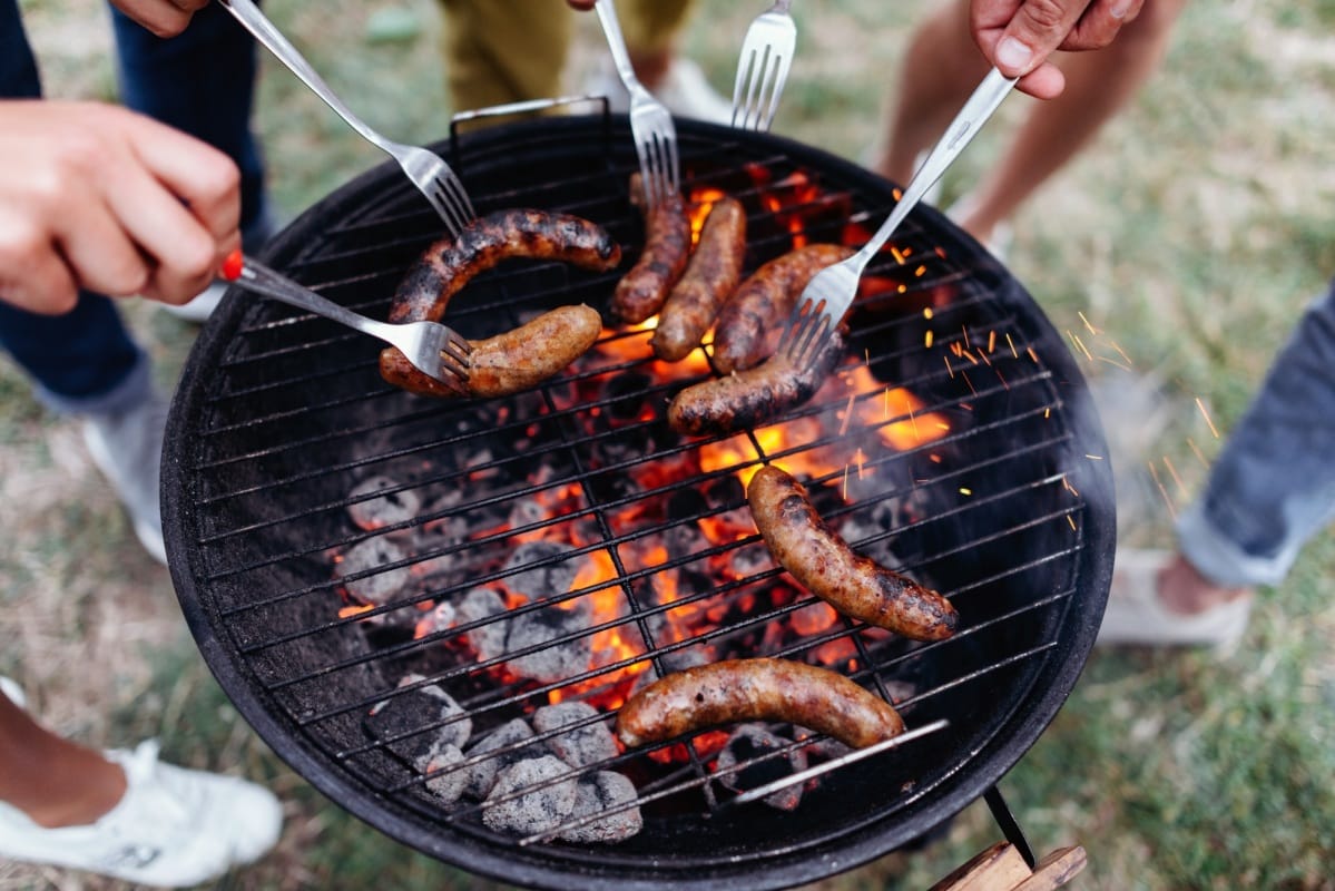 Gros plan sur des saucisses en train de cuire sur un barbecue