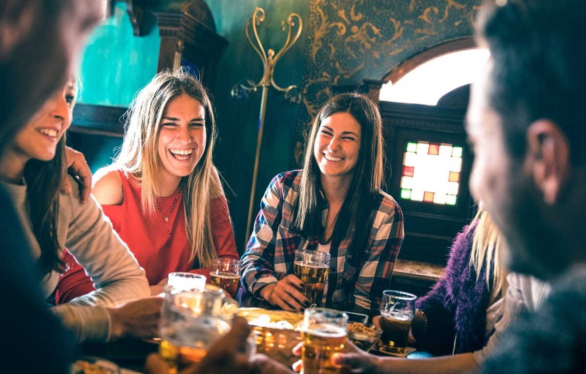 Groupe d'amis heureux buvant de la bière dans une brasserie, un bar ou un restaurant.