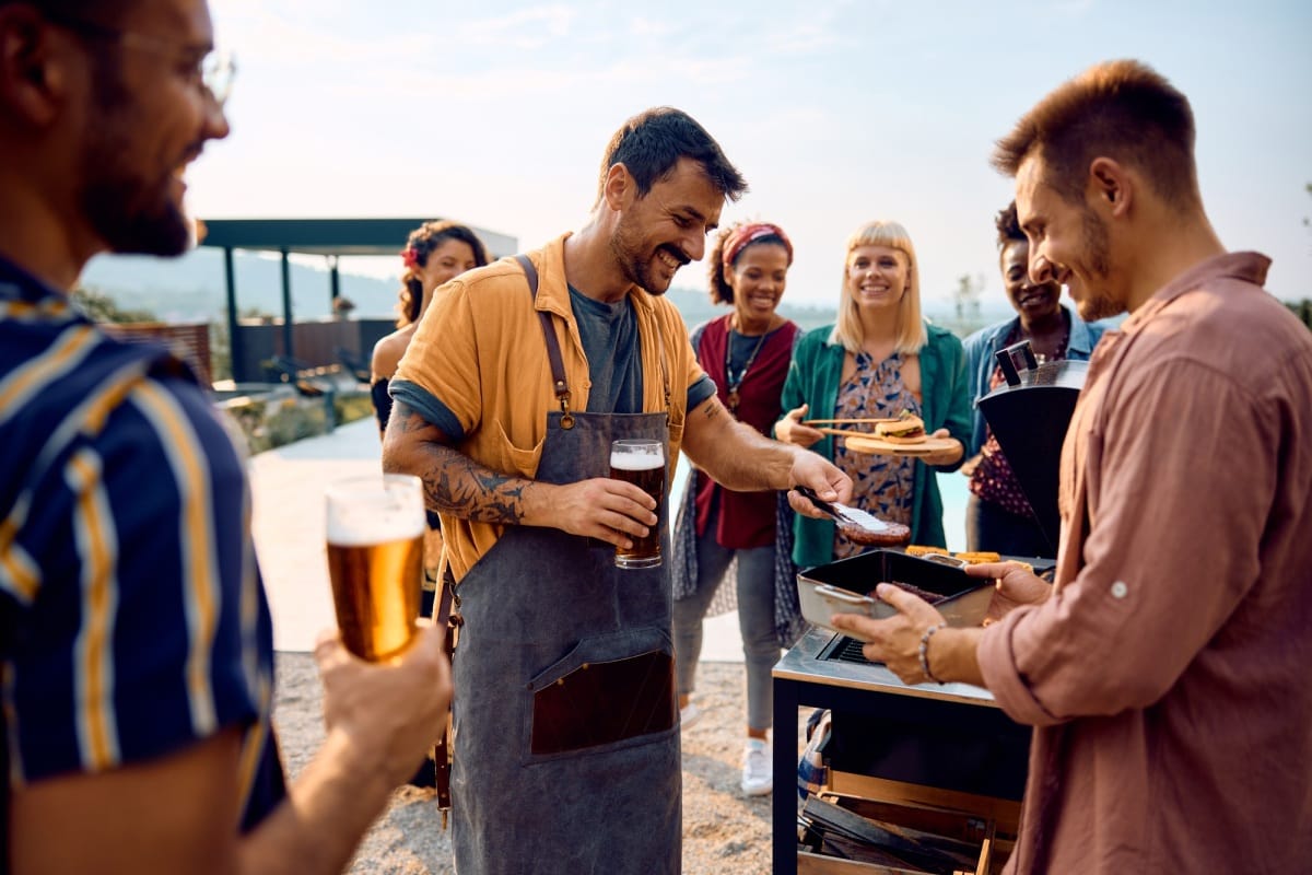 Groupe d'amis heureux de profiter d'un barbecue pendant une journée d'été.
