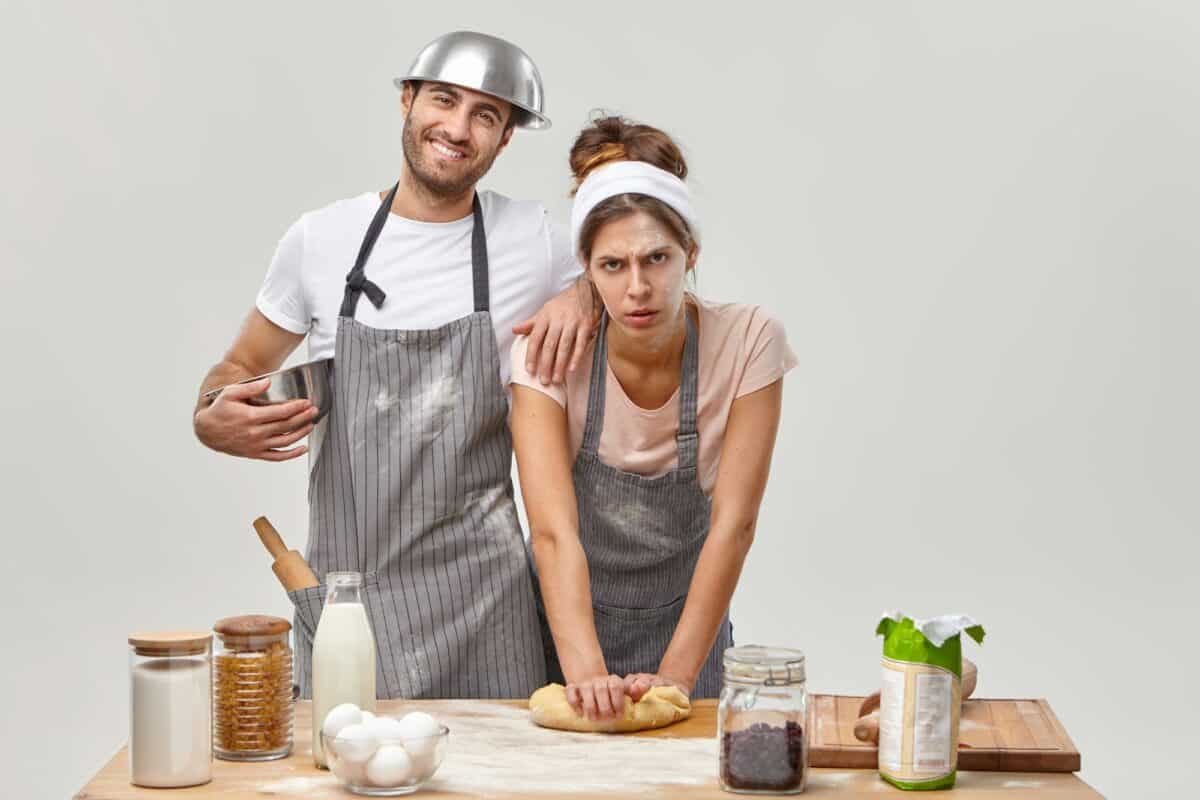 Home activities. Tired housewife and husband prepare homemade cookies, knead dough for baking, follo
