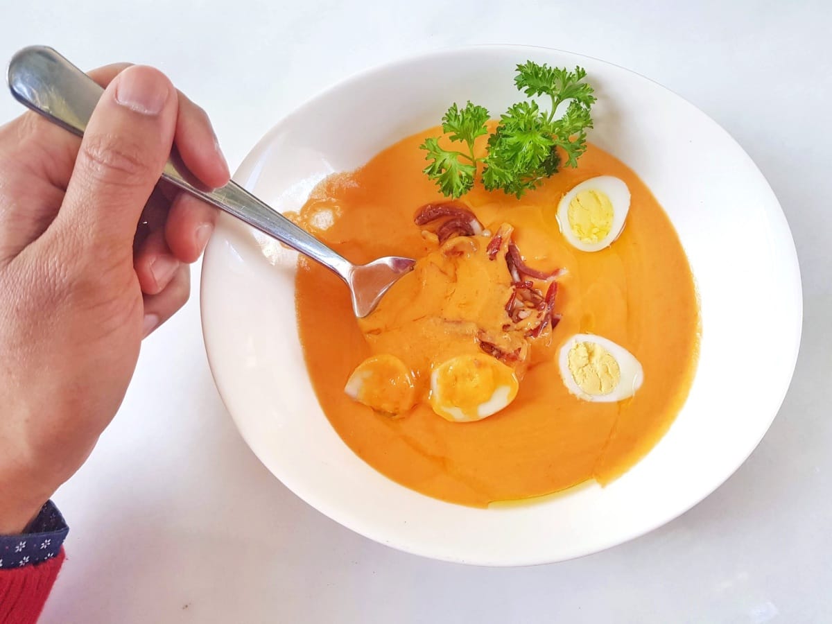 Homme mangeant du salmorejo, une soupe froide à l'orange typique de l'Andalousie, en Espagne.