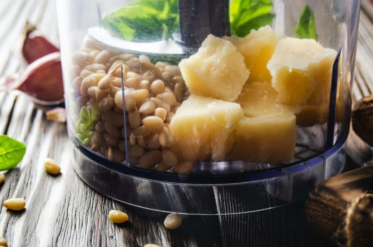 Ingrédients pour la sauce pesto italienne nationale traditionnelle genovese dans le bol du robot de cuisine