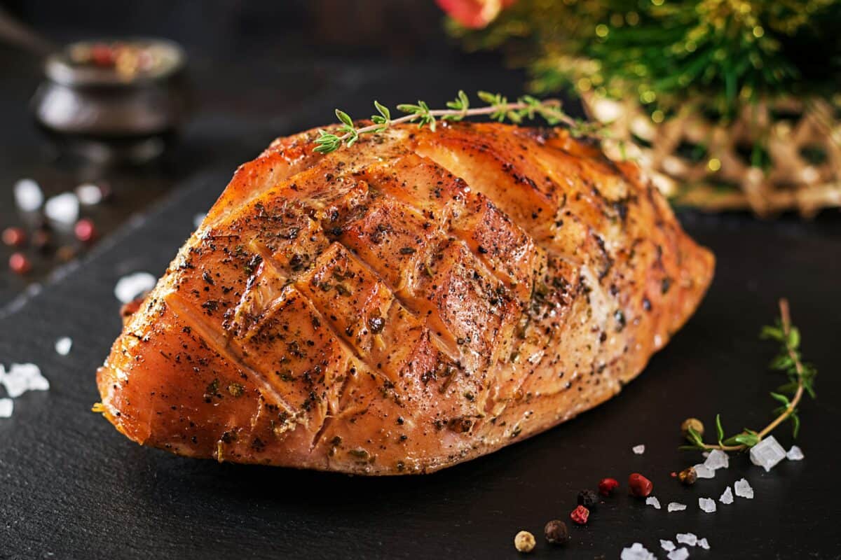 Jambon de Noël rôti ou dinde sur fond rustique foncé.  Nourriture de fête.
