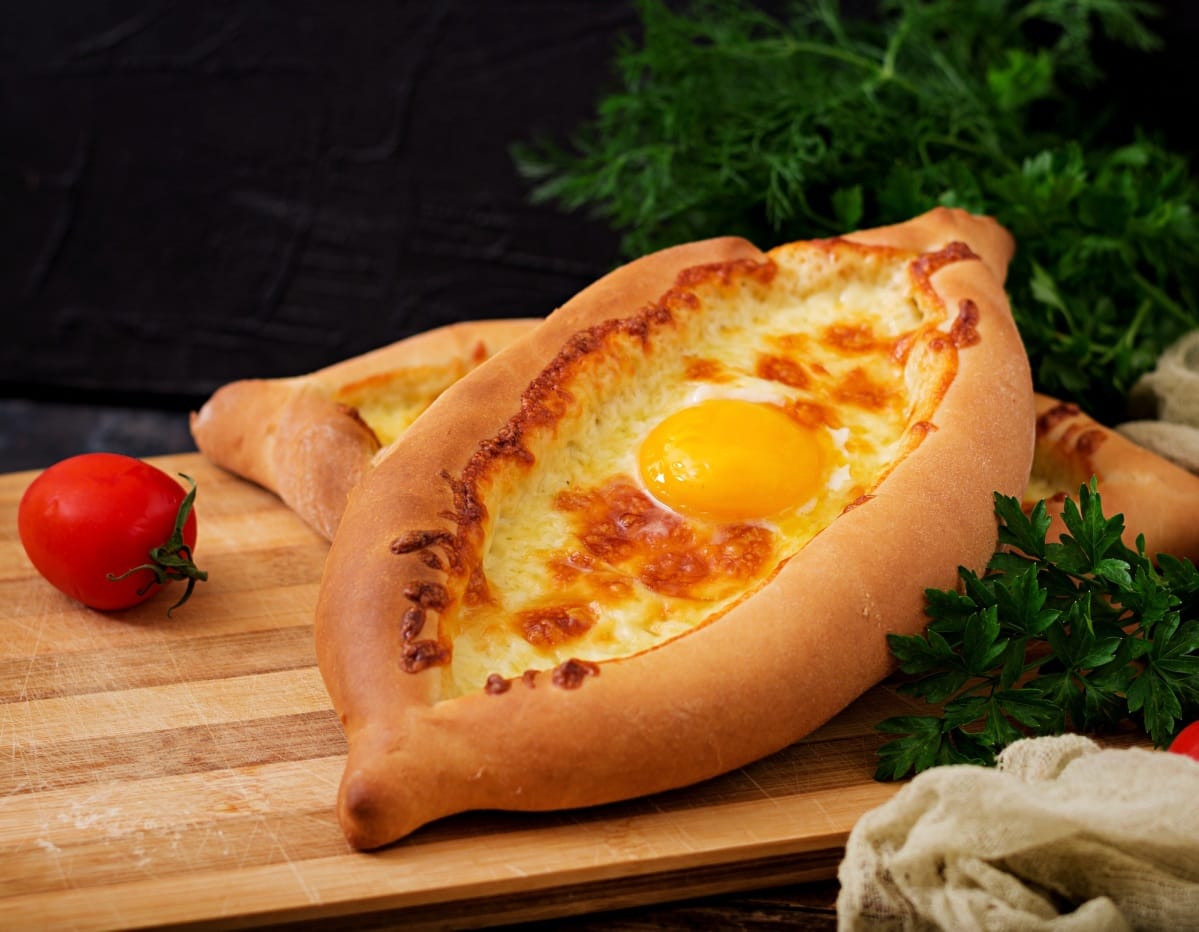 Khachapuri en langue adjare. Tarte ouverte à la mozzarella et à l'œuf. Cuisine géorgienne.