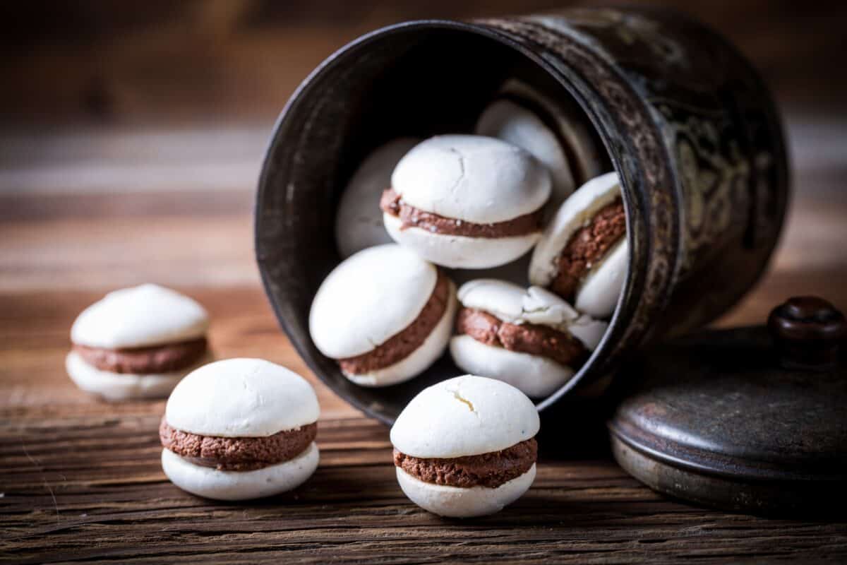 Macaroons with nut filling on old wooden table
