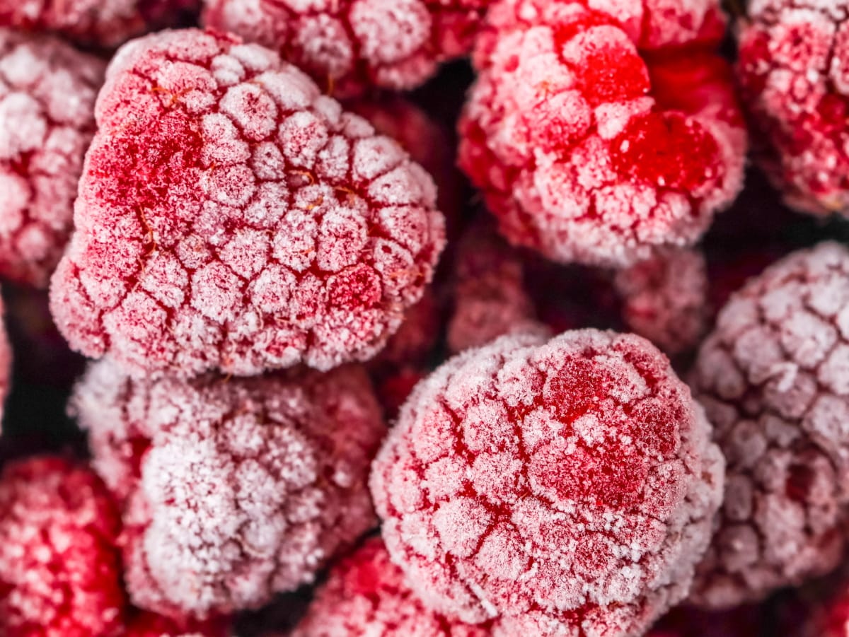 Magnifique arrière-plan de framboises rouges congelées.