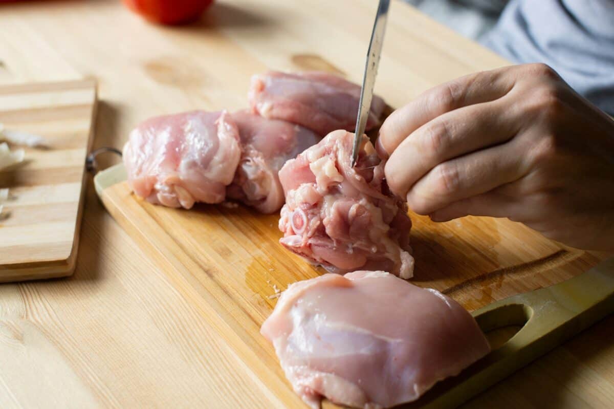Men's hands butcher poultry meat