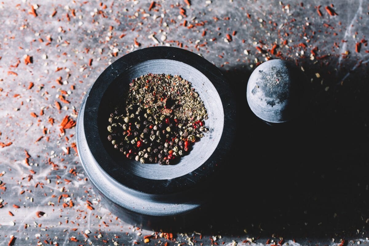 Mixed colorful grains of pepper in a mortar