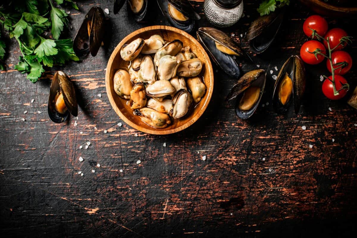 Moules marinées dans un plat en bois sur la table.