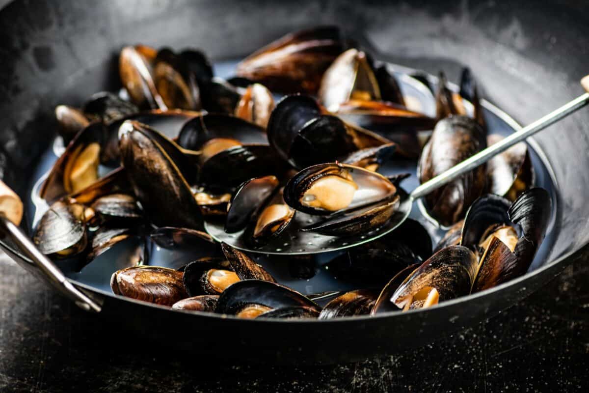 Mussels are cooked in a pot of water.