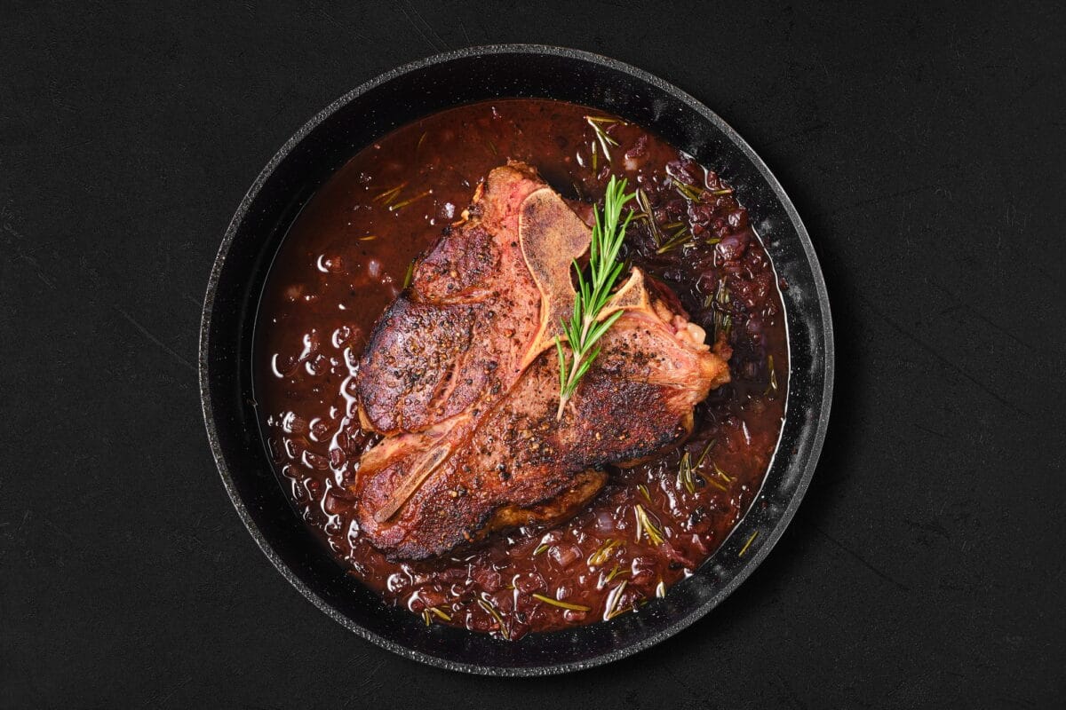 Overhead view of Porterhouse steak in wine sauce