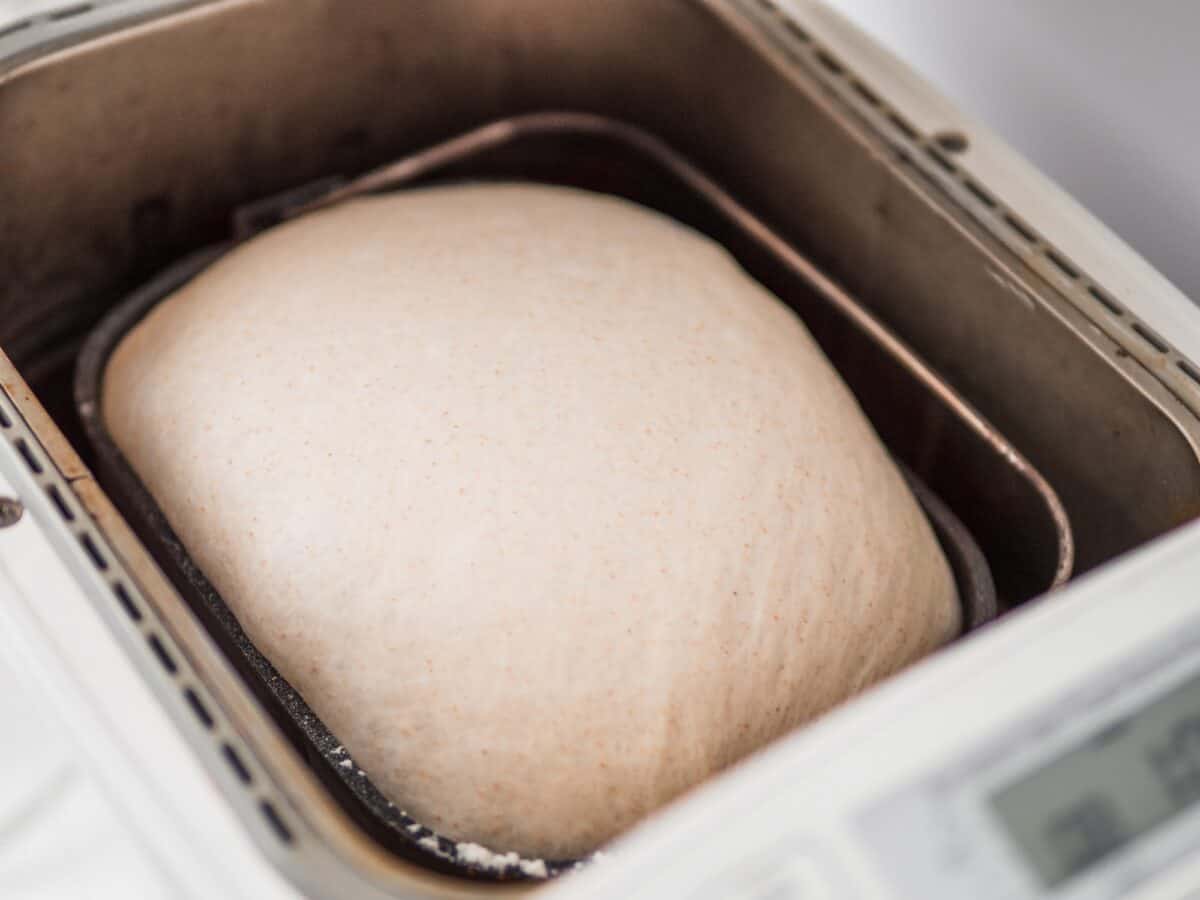 Pain tranché savoureux et machine à pain sur la table
