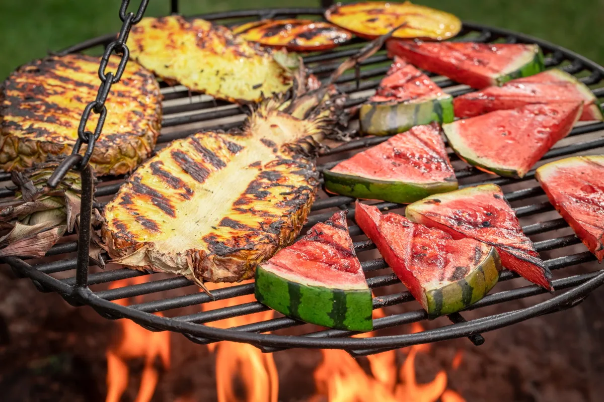 Pastèque et ananas grillés avec des flammes sur un feu de joie.