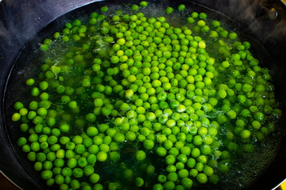 Pois verts en train de cuire dans un wok.