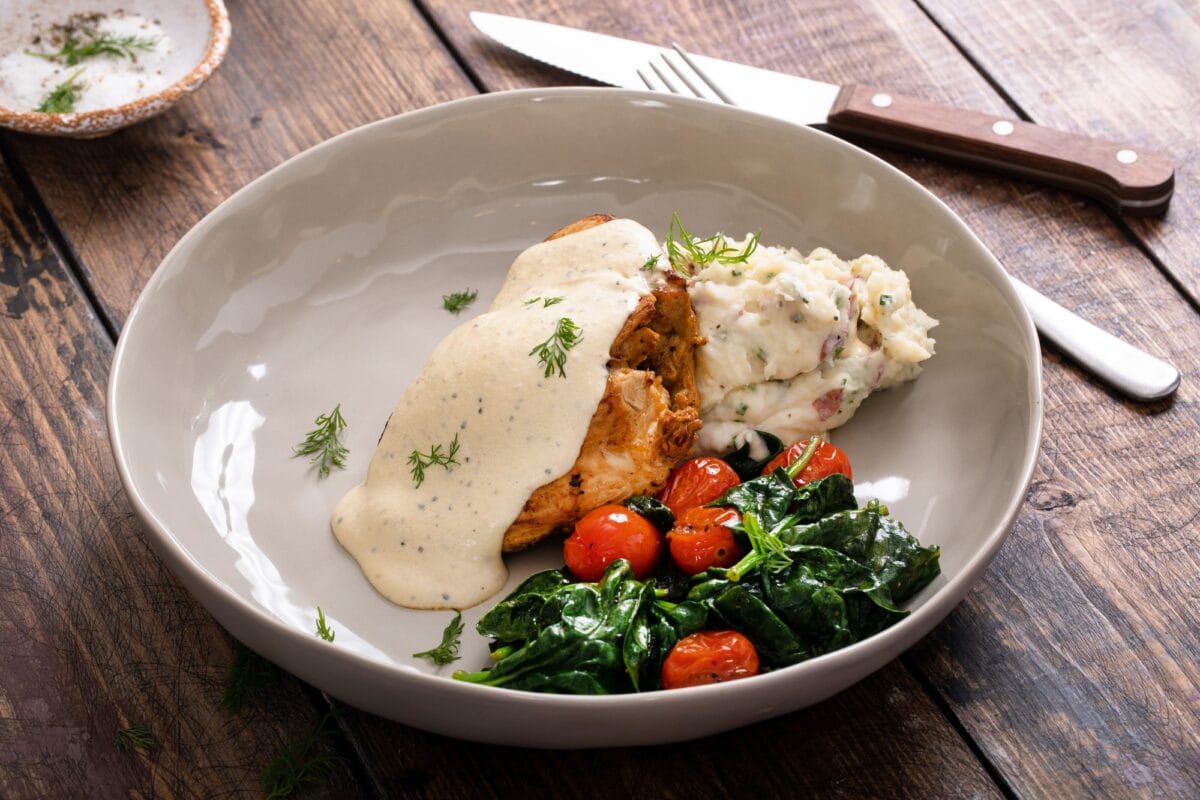Roasted chicken thighs served with creamy sauce and mashed potatoes