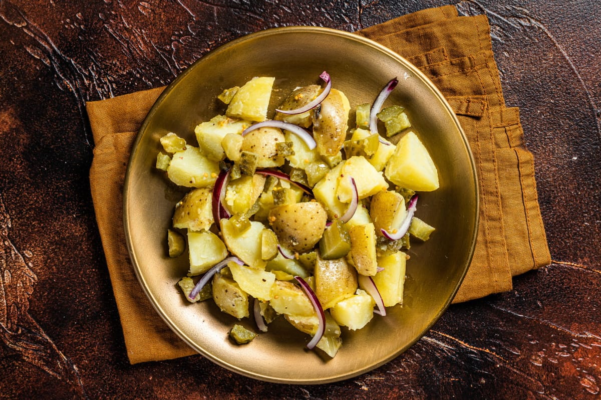 Salade de pommes de terre avec oignon rouge, câpres et légumes verts.