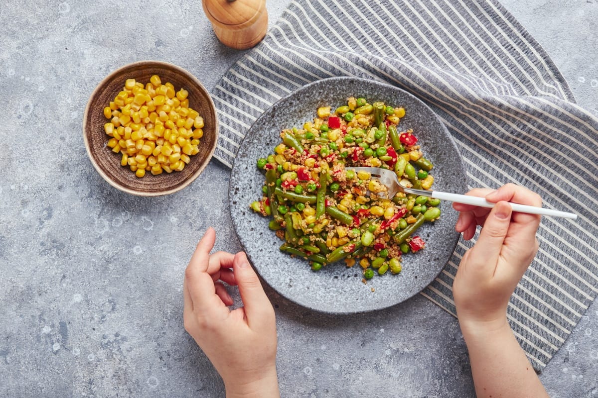 Salade de quinoa avec haricots verts, maïs, poivrons rouges, petits pois et soja. Mélange de légumes utiles