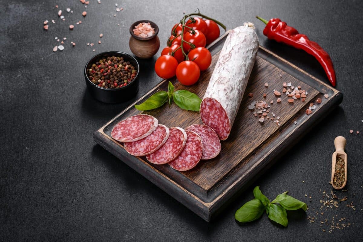Spanish dried sausage salami on a dark concrete background