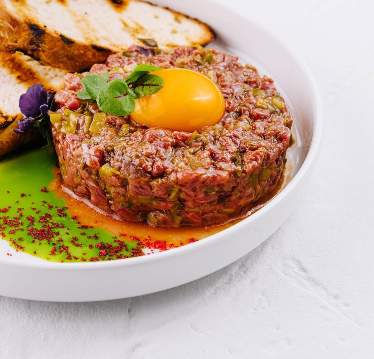 Steak tartare gourmet avec jaune d'œuf et pain grillé