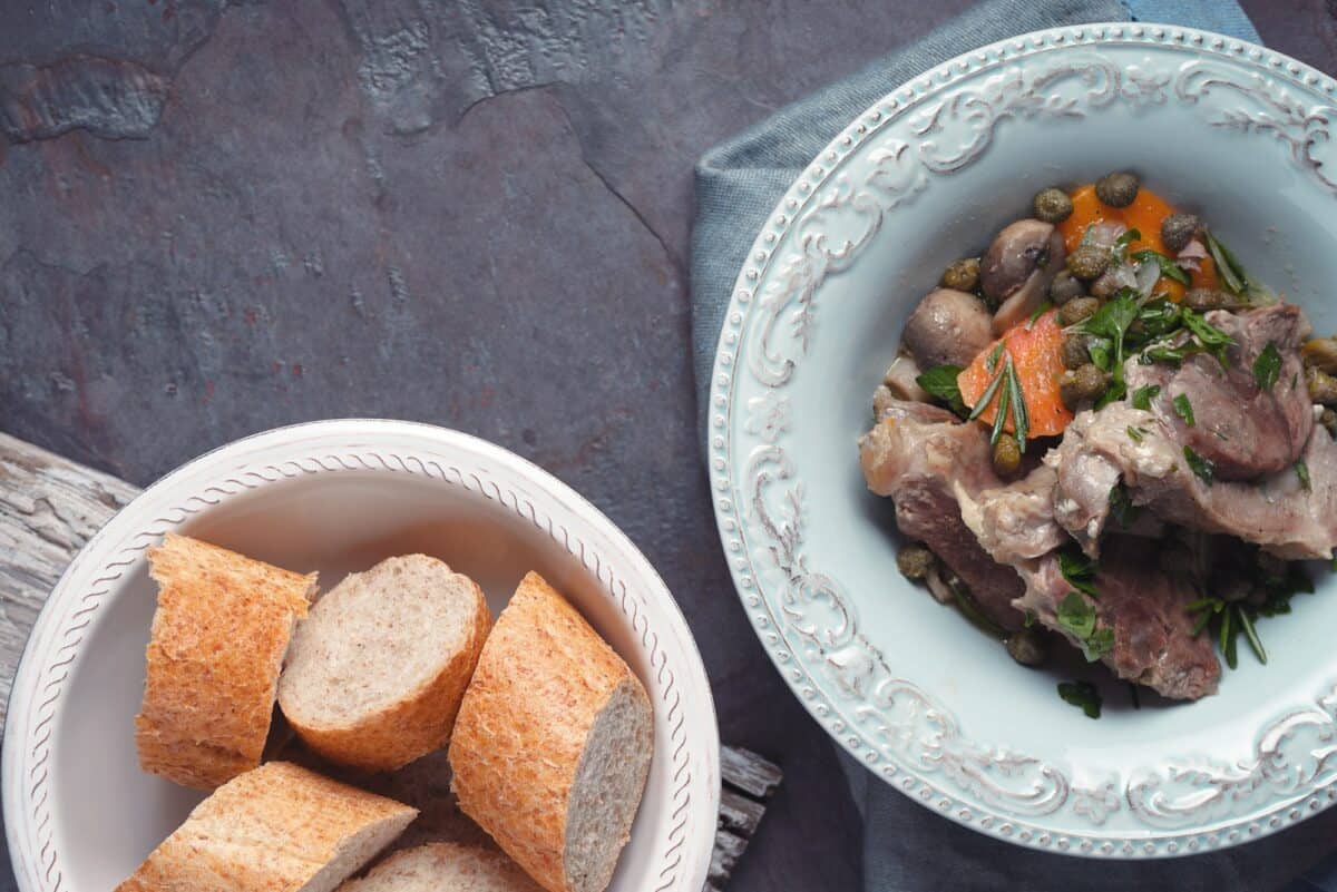 Stew meat with vegetables and bread on the stone background top view