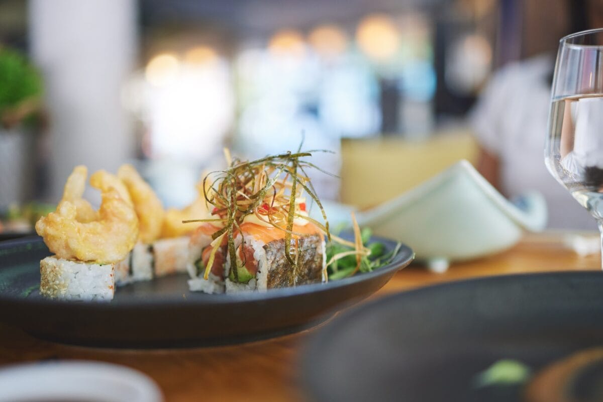 Sushi restaurant, catering and seafood in closeup for service, brunch or dinner with wine, glass an