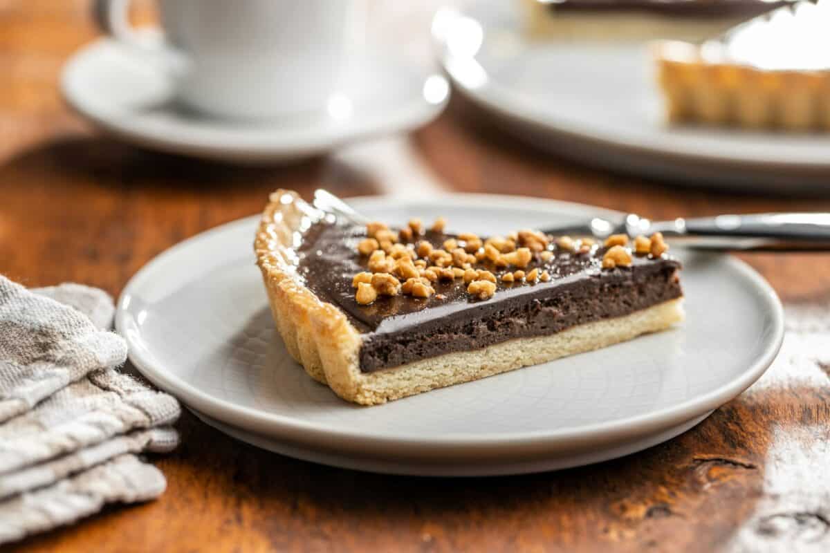 Tarte au chocolat sucrée avec des noix concassées.