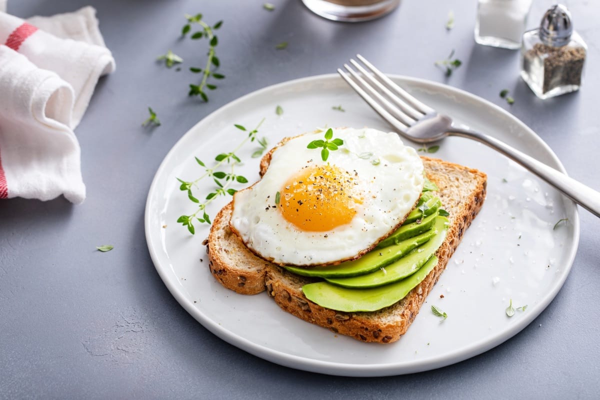 Tartine d'avocat sur un pain multigrains grillé avec un œuf au plat