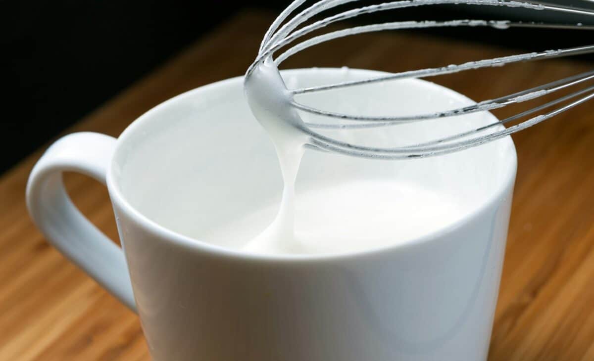Tasse d'œufs battus, crème fouettée et mixer