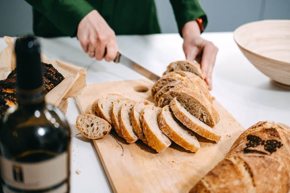 Slicing Artisan Sourdough Bread on Wooden Board