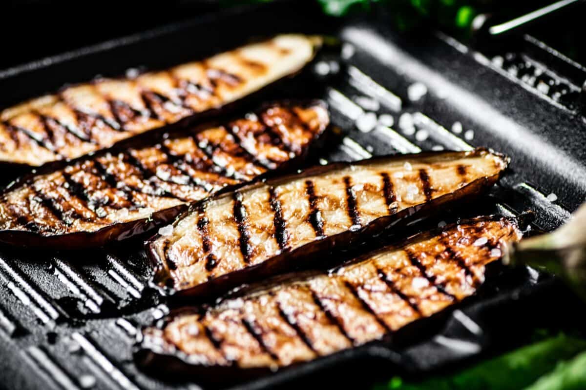 Tranches d'aubergine dans une poêle à griller.