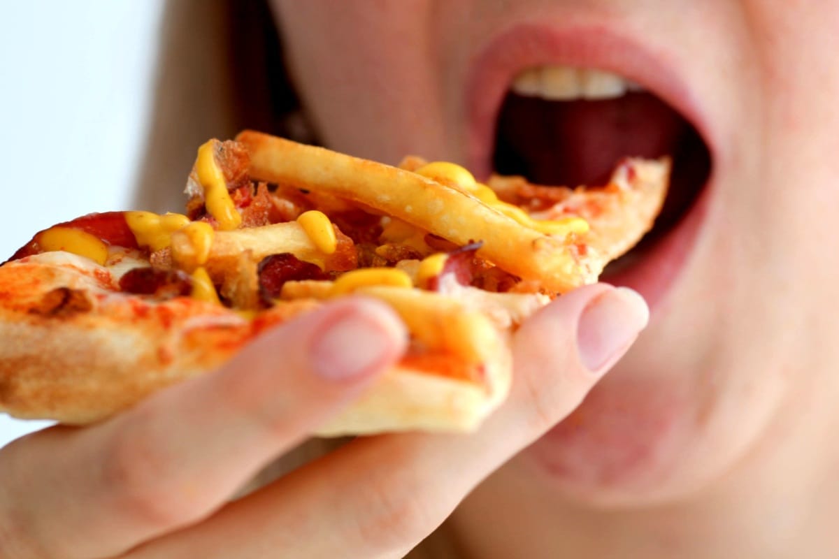 Woman  eats pizza, of mischievous calories and harmful cholesterol.